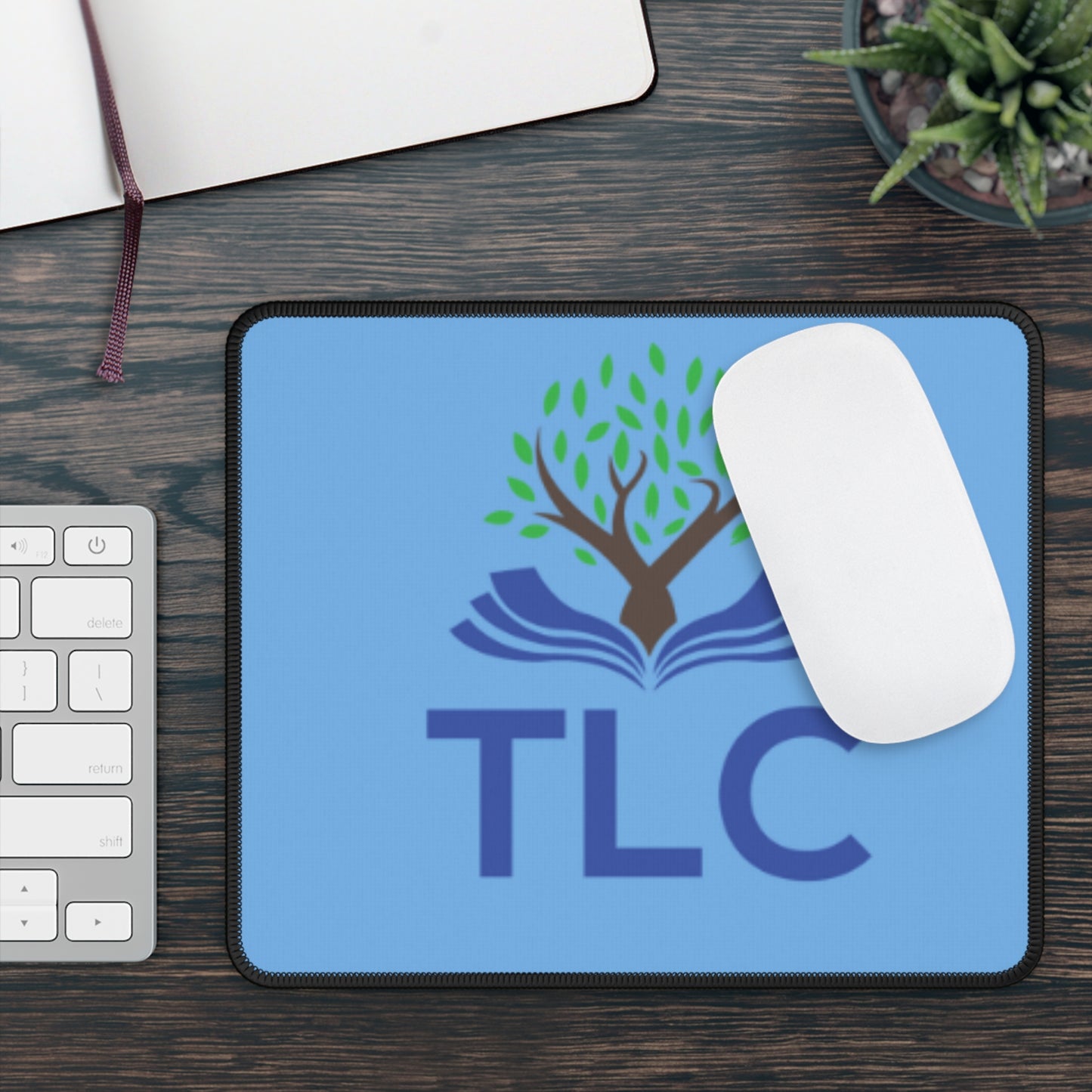 Blue mouse pad with TLC logo on a wooden desk