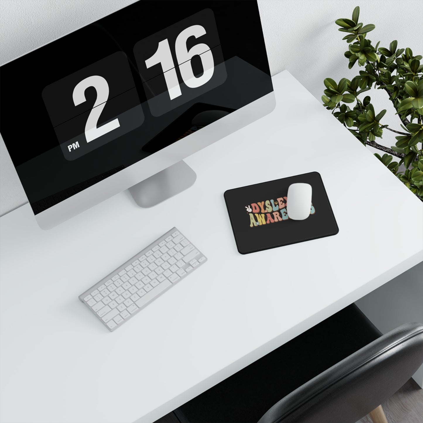 Computer monitor with digital clock display on a desk with keyboard and mouse.