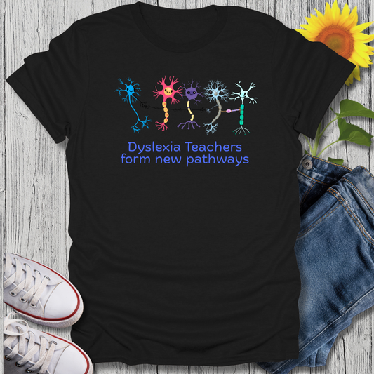 Black t-shirt with colorful neuron graphics and text on a wooden surface with jeans and sneakers.