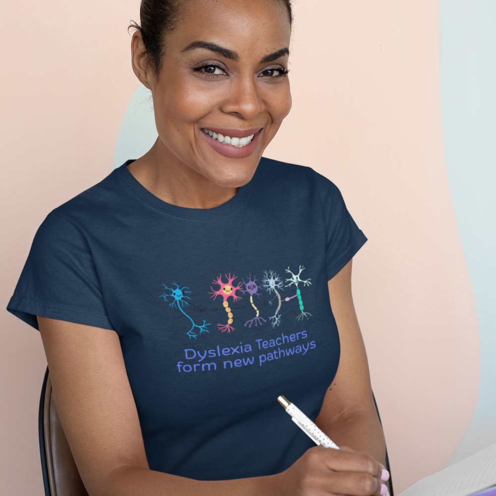 Woman wearing a navy blue t-shirt with a graphic and text, holding a marker against a light pink background