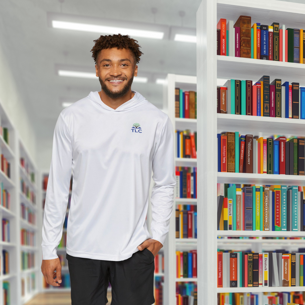 Man wearing a white hoodie with a logo standing in a library.