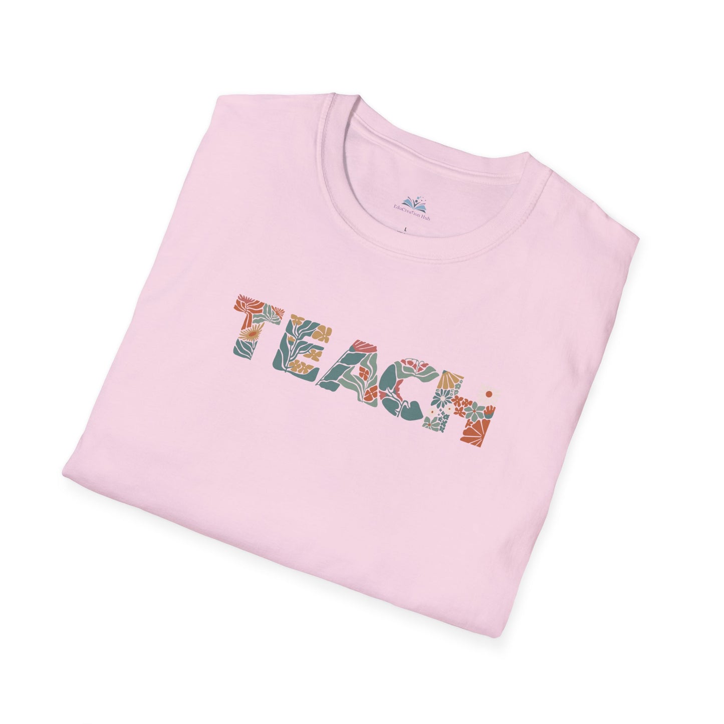 Folded pink t-shirt with 'TEACH' printed on it against a white background