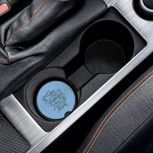Car cup holder with a blue coaster featuring text