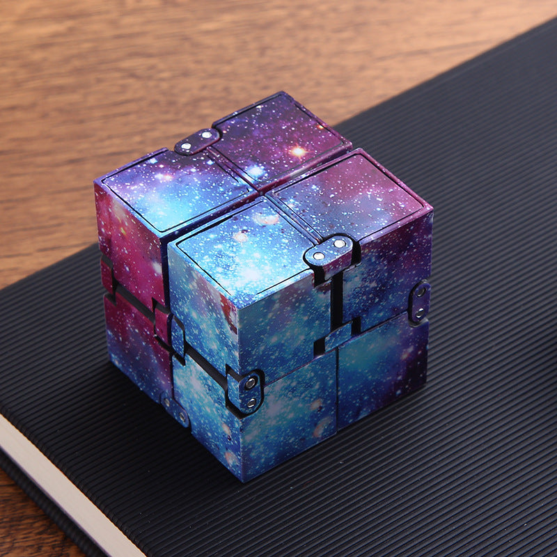 Colorful galaxy-themed fidget cube on a dark surface