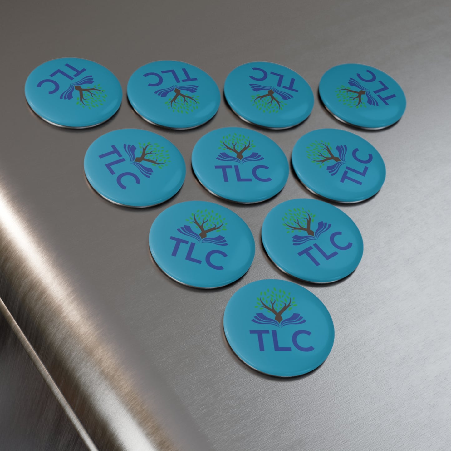 Blue circular stickers with 'TLC' logo on a metallic surface