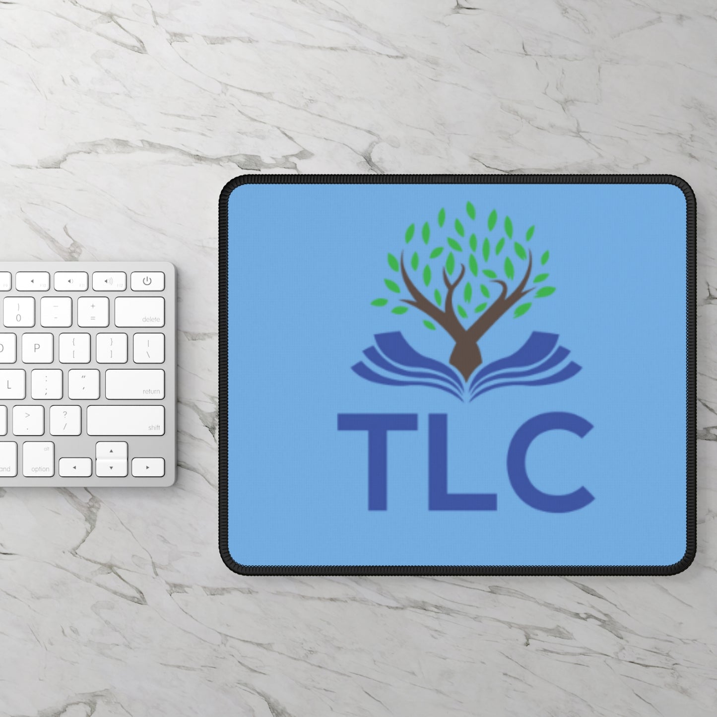 Tablet with TLC logo on a marble surface with a keyboard