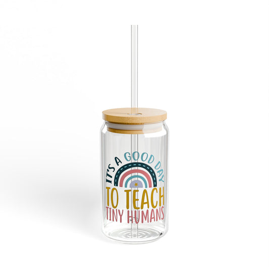 Clear tumbler with wooden lid and colorful text design on a white background