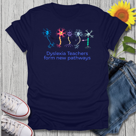 Navy blue t-shirt with colorful neuron graphics and text, placed on a wooden surface with jeans and sneakers.
