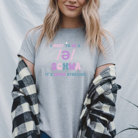 Person wearing a gray t-shirt with colorful text and plaid sleeves.