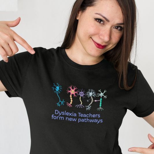 Woman wearing a black t-shirt with colorful neuron graphics and text, pointing to the shirt.