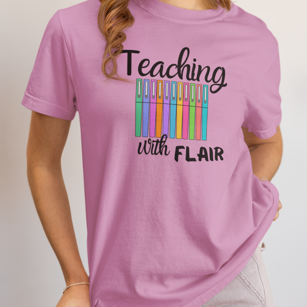 Pink t-shirt with 'Teaching with Flair' text and colorful pens design on a plain background