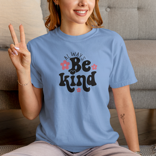 Person wearing a blue t-shirt with 'Always Be Kind' text, sitting on a couch.