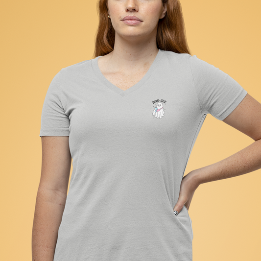 Person wearing a gray t-shirt with a logo on a beige background
