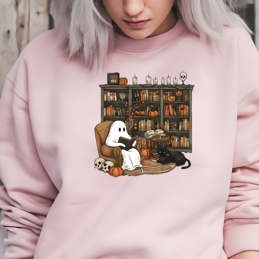 Person wearing a pink sweatshirt with a ghost reading a book design.