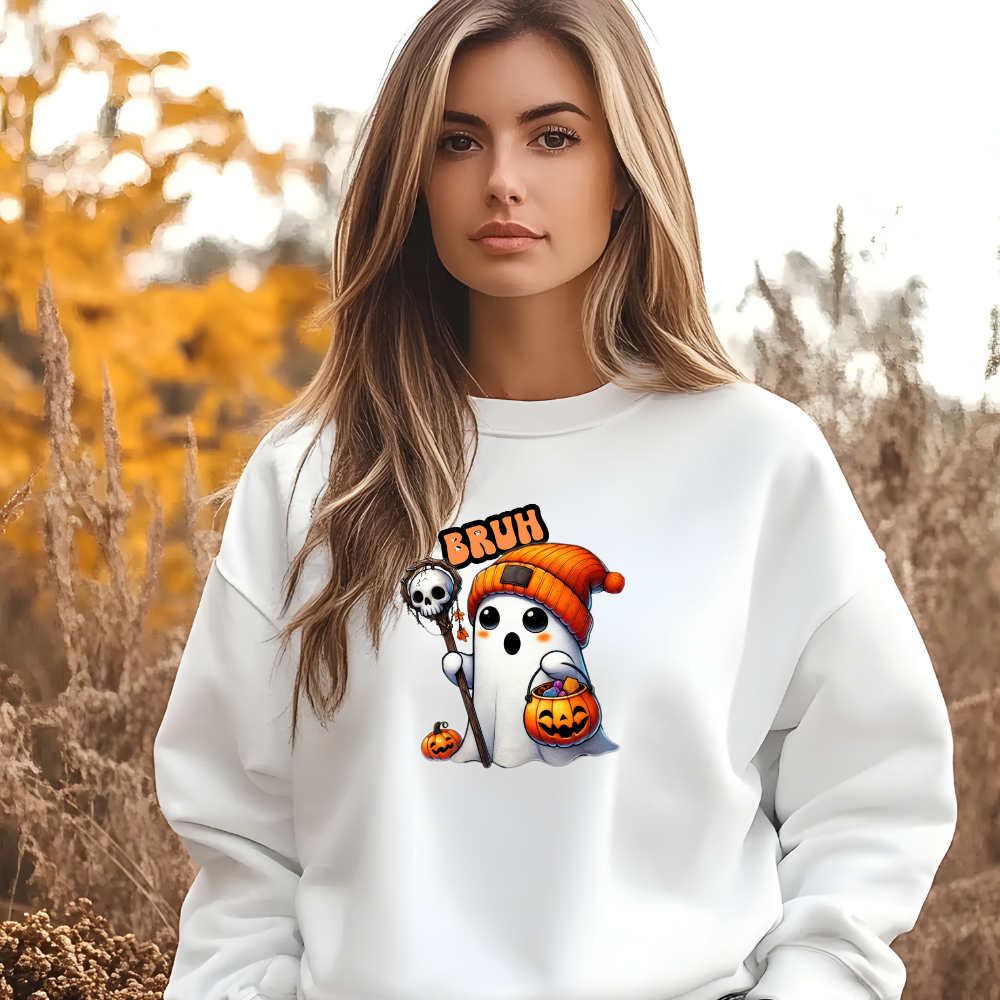 Woman wearing a white sweatshirt with Halloween-themed graphics in an outdoor setting.