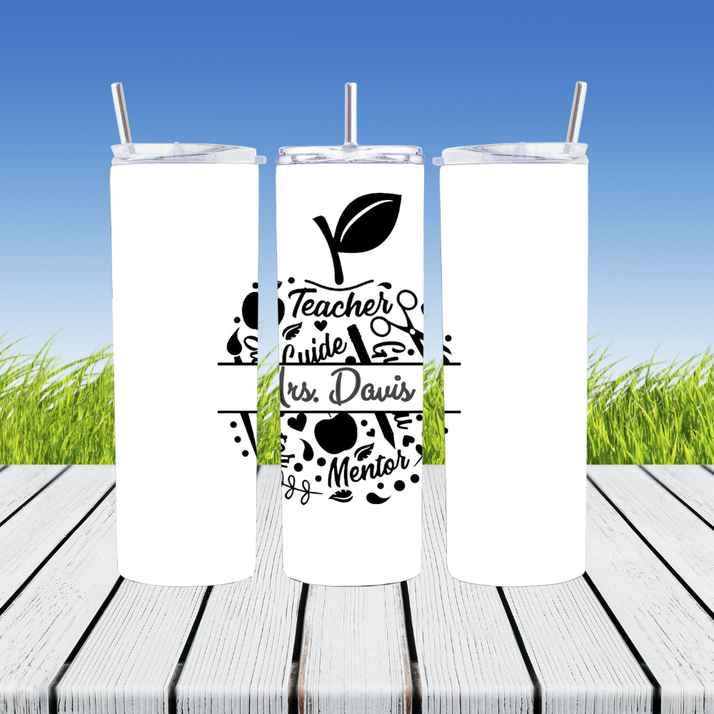 Three white tumblers with black text and graphics on a wooden surface with grass in the background.