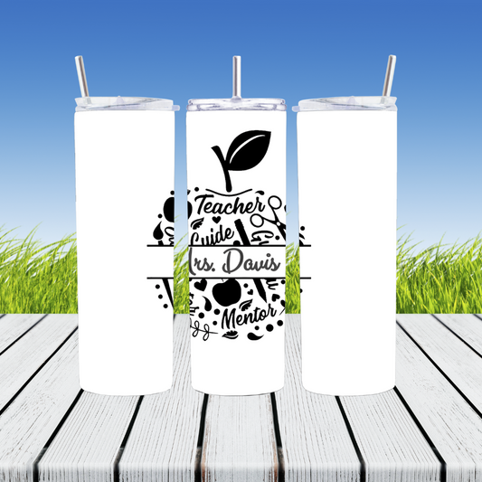 Three white tumblers with black text and graphics on a wooden surface with grass in the background.