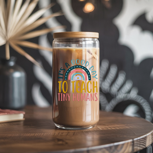 Glass jar with a wooden lid containing coffee, featuring a colorful quote on a wooden table.