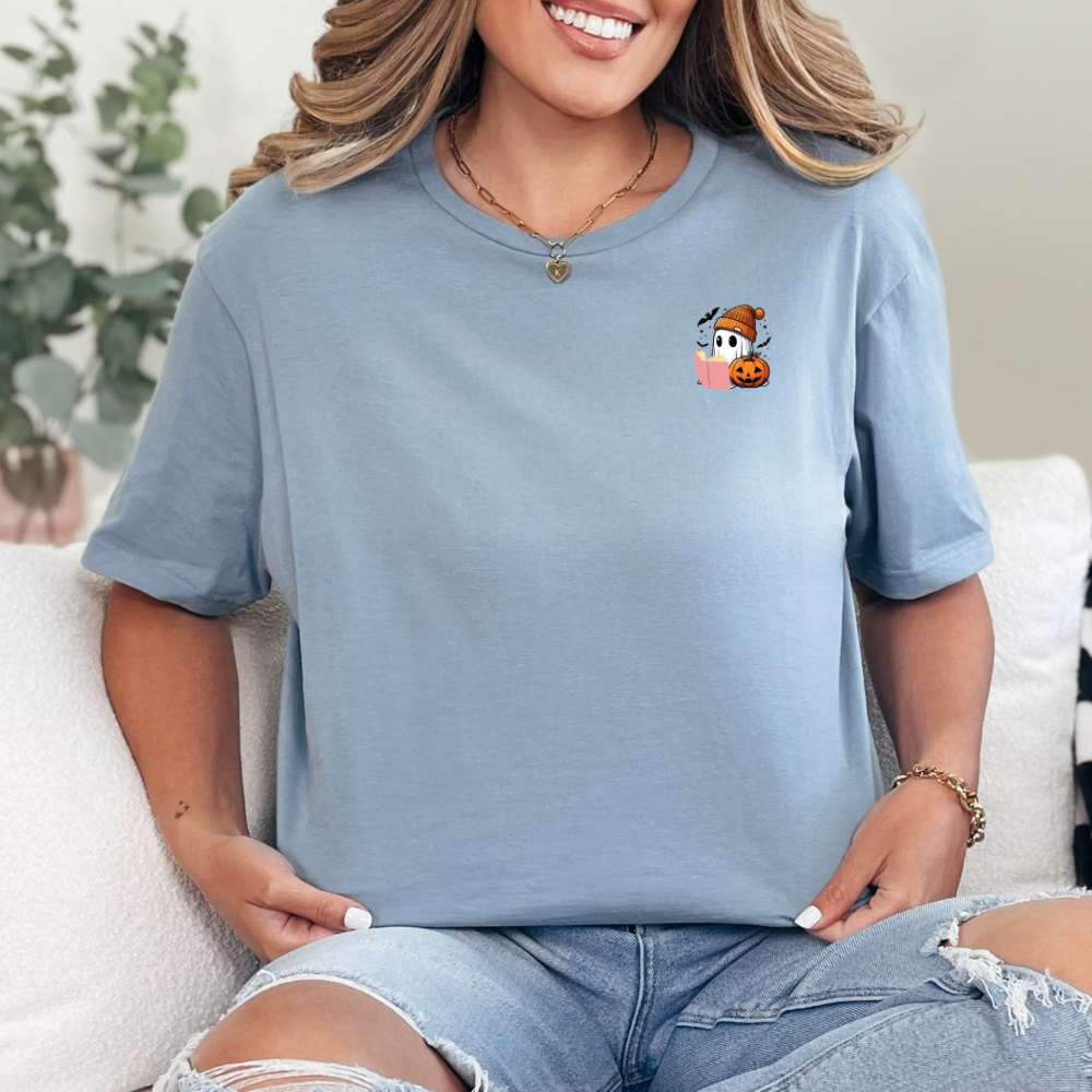 Person wearing a blue t-shirt with a small graphic design, sitting on a white couch.