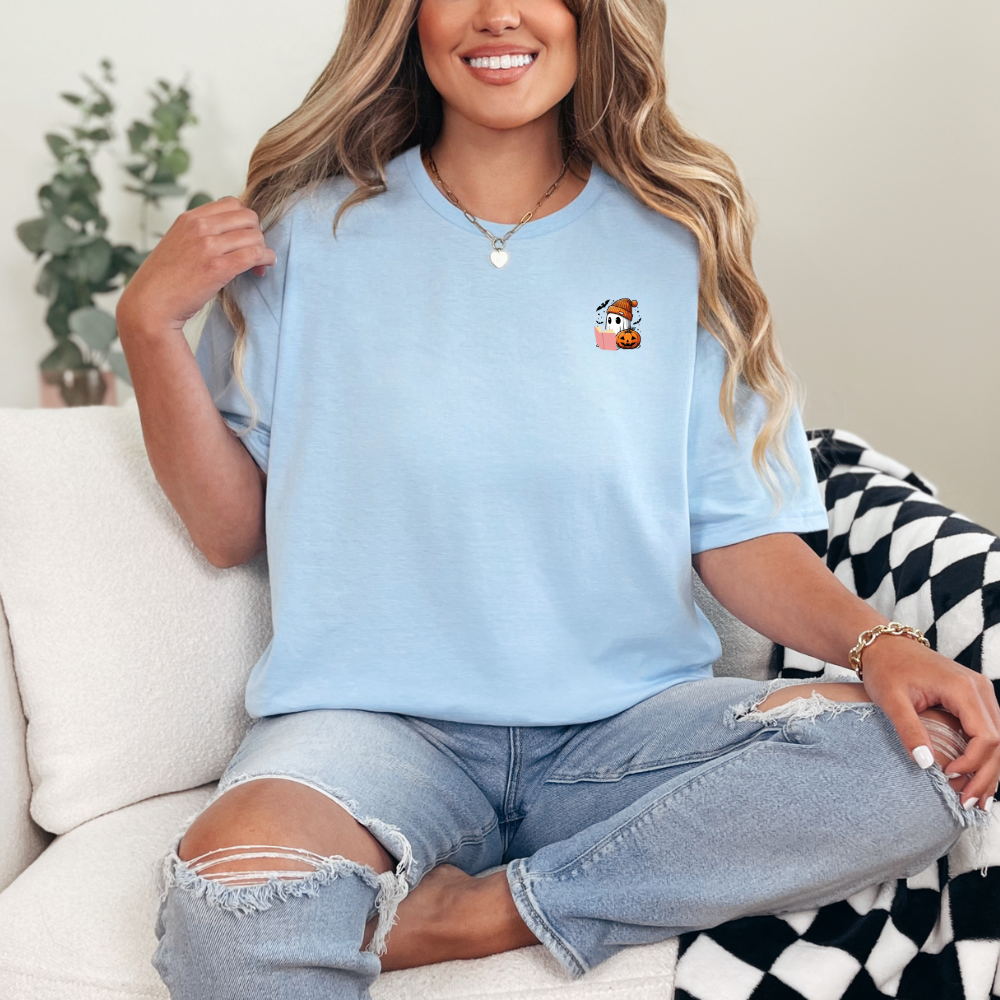 Woman wearing a light blue t-shirt with a small graphic on a couch.