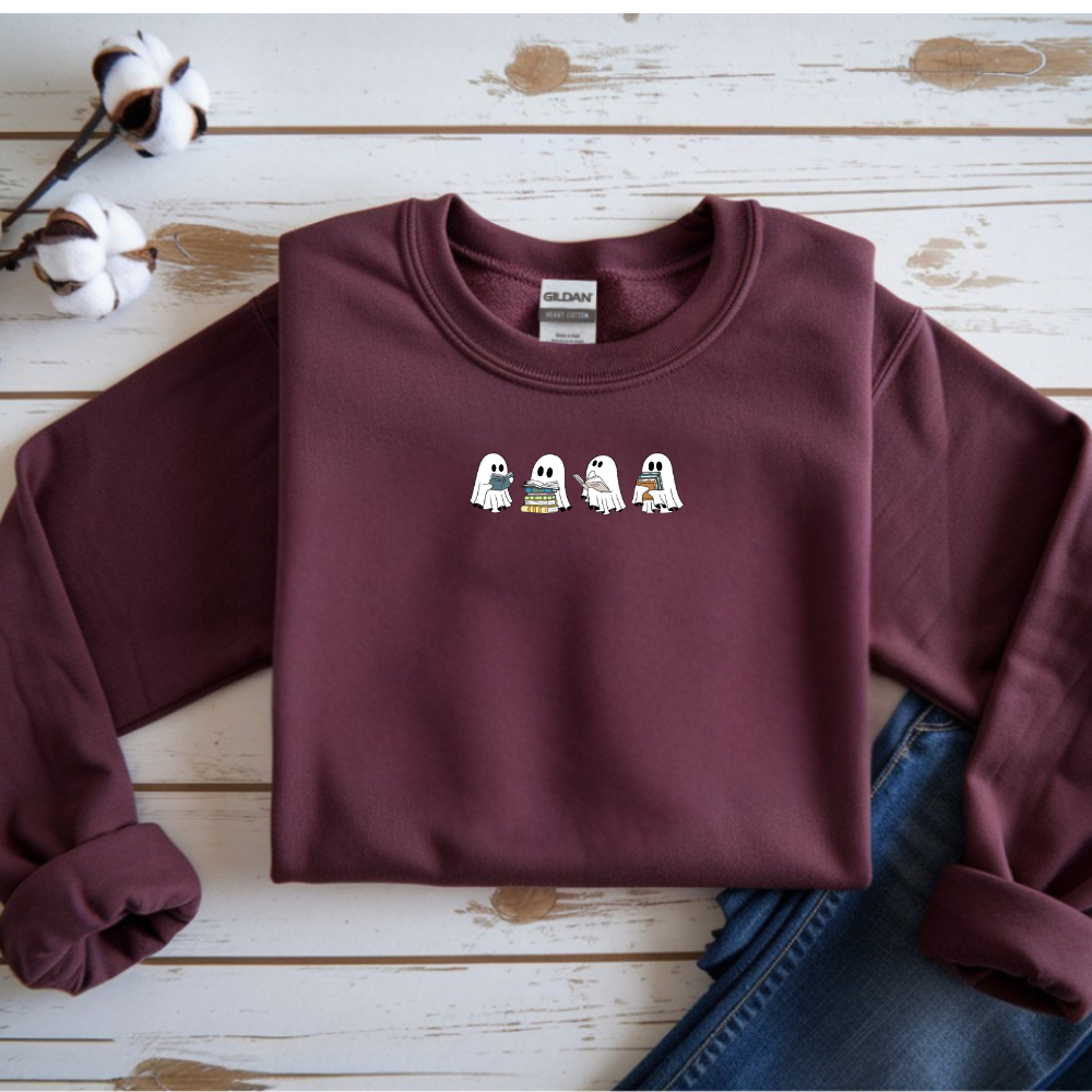Maroon sweatshirt with ghost design on a wooden surface