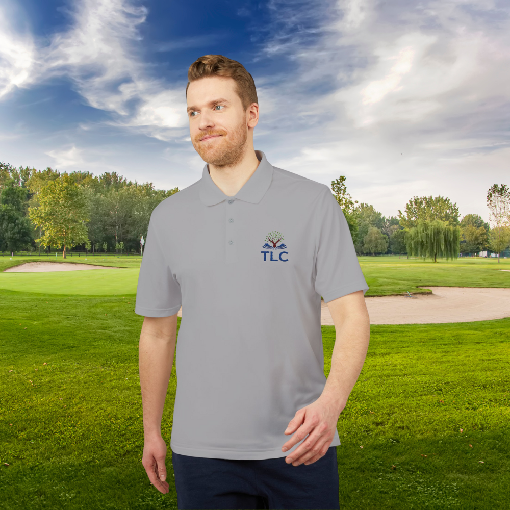 Man wearing a gray polo shirt with a logo on a golf course