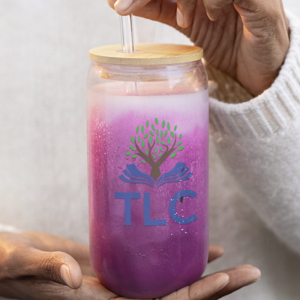 Person holding a purple tumbler with a straw, featuring a logo and 'TLC' text.