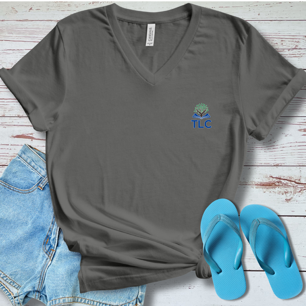 Gray t-shirt with TLC logo, blue shorts, and blue flip-flops on a wooden surface